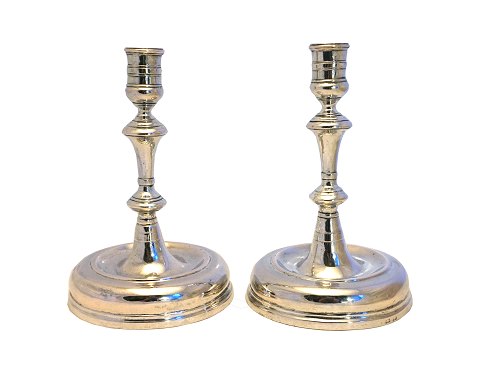 A pair of silver candle holders with feet. Around 
1750
