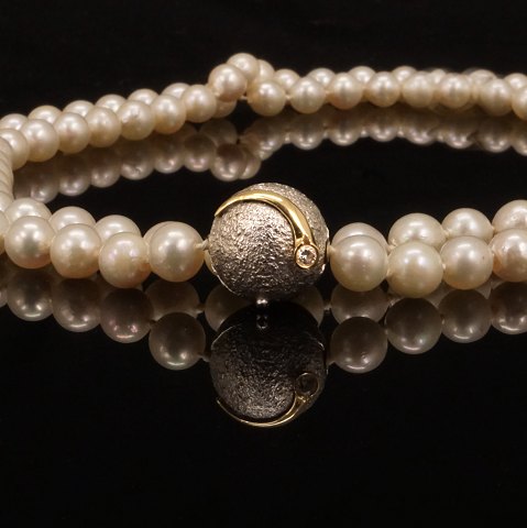 An Ole Lynggaard, Copenhagen, 14kt whitegold clasp 
with a diamond. D: 14mm