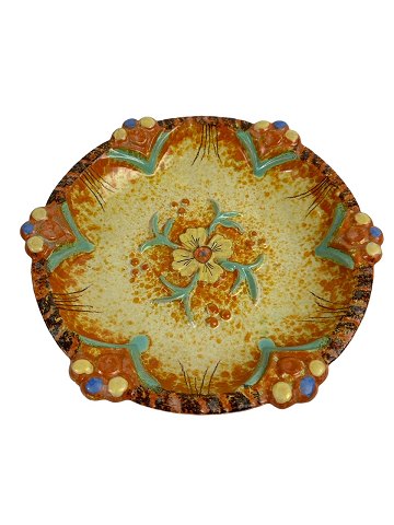 Stort fad med blomst i relief i gule og orange farver. Usgineret, men i stil med svenske Ekeby samt tyske West Germany