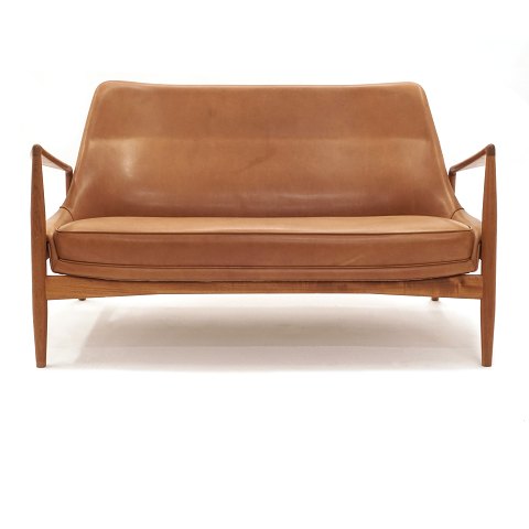 Ib Kofod-Larsen "The Seal" two seater sofa, teak 
and leather, by Brdr. Petersen, Denmark. Nice 
condition. L: 138cm