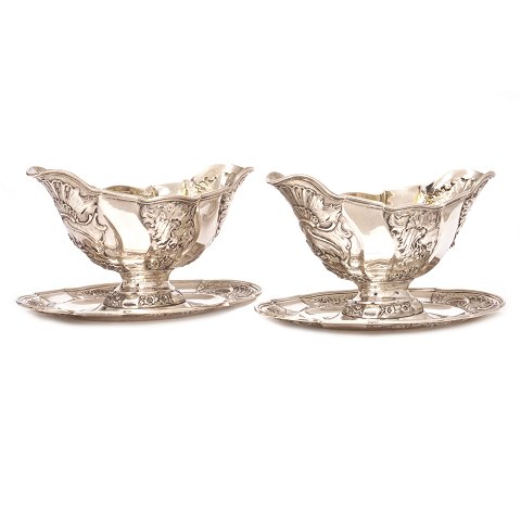 Et par kraftige saucieres i sølv udført af A. 
Michelsen København dateret 1898 & 1901. H: 13cm. 
L: 22cm. V: 1.244gr (2 stk)