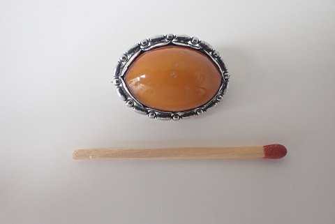 Evald Nielsen - lille skønvirke broche i sterling sølv med cabochonslebet 
mælkerav.