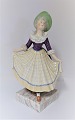 Royal Copenhagen. Figure. Elegant woman. Model 1396. Height 21 cm. There are small chips on the lace edge. (1 quality)