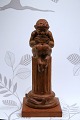 Decorative, old Pan figure sitting on a pillar carved in wood.