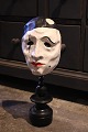 Decorative, old clown mask in painted papier-mâché mounted on old black painted 
wooden base...