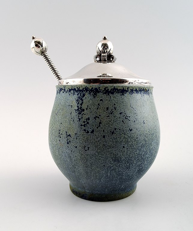 Arne Bang and others .: b. Frederiksberg 1901, d. Fensmark 1983.Jam Jar in stoneware decorated with speckled blue-green glaze. Lid and spoon in sterling silver.