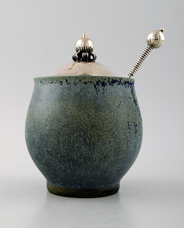 Arne Bang and others .: b. Frederiksberg 1901, d. Fensmark 1983.Jam Jar in stoneware decorated with speckled blue-green glaze. Lid and spoon in sterling silver.