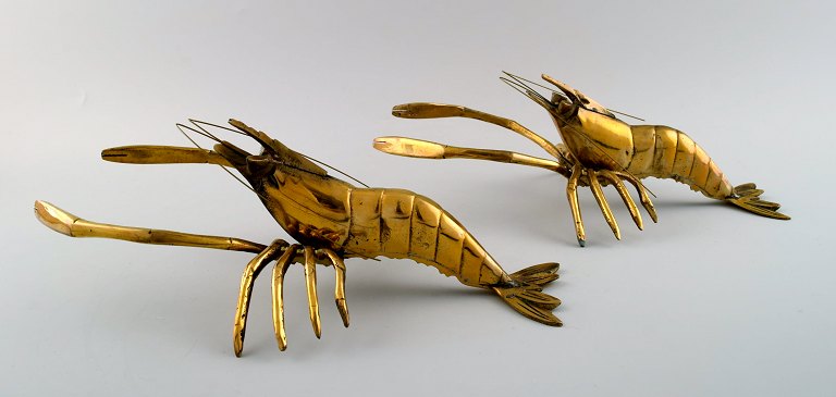 Two brass table decorations in the shape of lobsters.