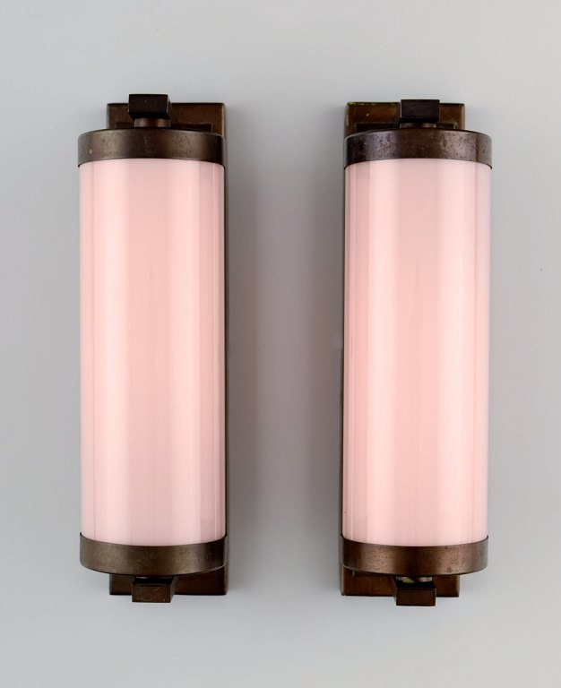 Scandinavian designer, a pair of Art Deco wall lamps in brass with pink glass shades.