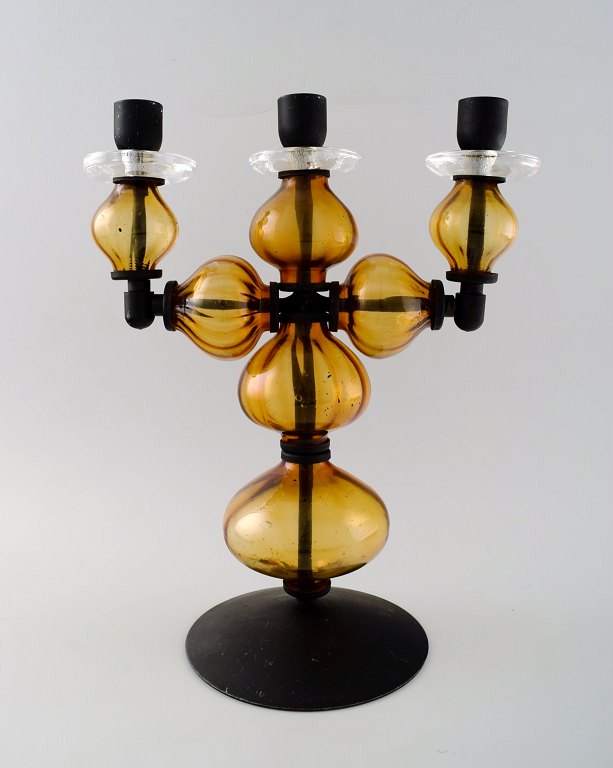 Erik Höglund for Kosta Boda, large three-armed candlestick of cast iron with hand-blown art glass.
