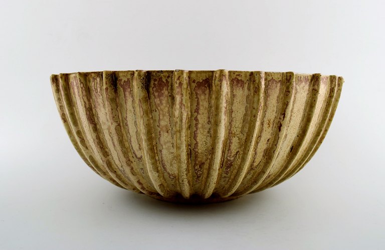 Arne Bang. Stoneware bowl with fluted corpus decorated with brown / ocher speckled glaze.