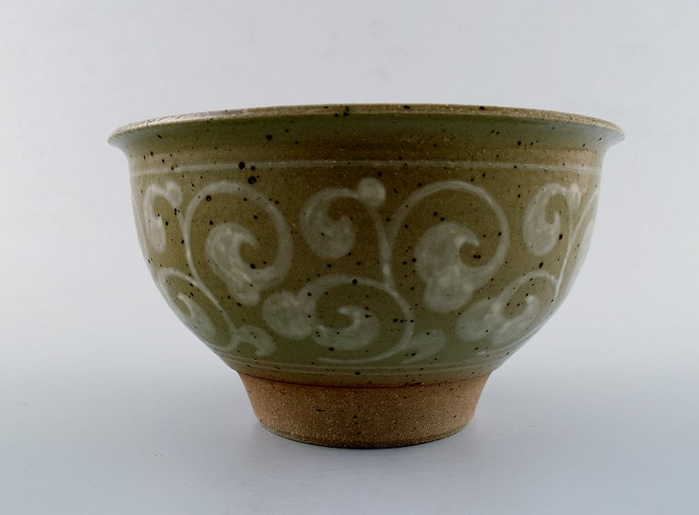 Unique Erik Reiff for Royal Copenhagen. Stoneware bowl, decorated with bright spiral pattern on green background.