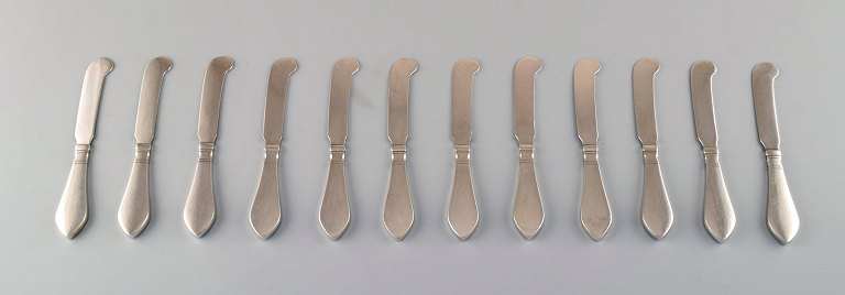 Tolv Georg Jensen Antik Sterlingsølv, smørknive i helsølv. 