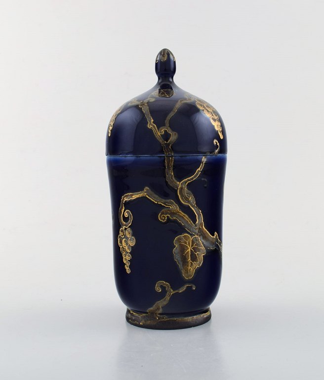 Karl Lindström and Nils Emil Lundström for Rörstrand. Lidded porcelain jar decorated with grape vines in gold on beautiful dark blue base. Japanism, ca. 1920.