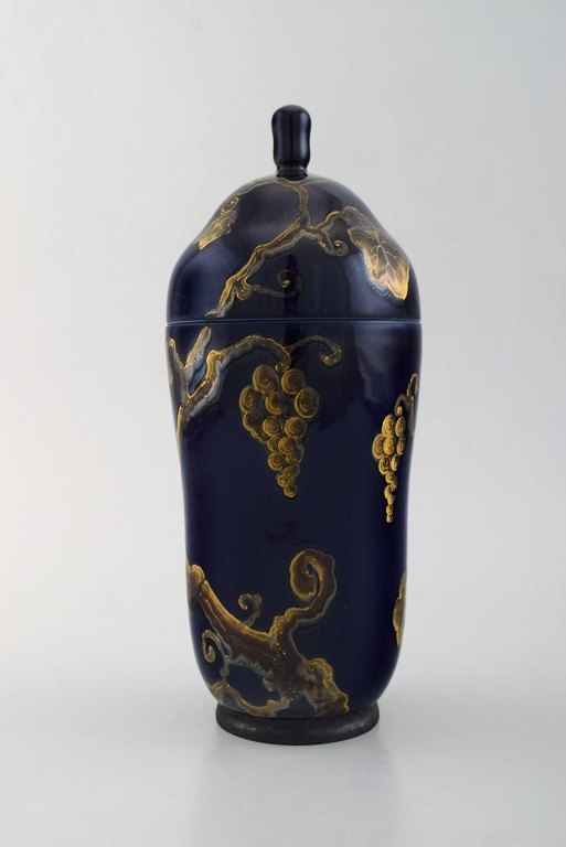 Karl Lindström and Nils Emil Lundström for Rörstrand. Lidded porcelain jar decorated with grape vines in gold on beautiful dark blue base. Japanism, ca. 1920.