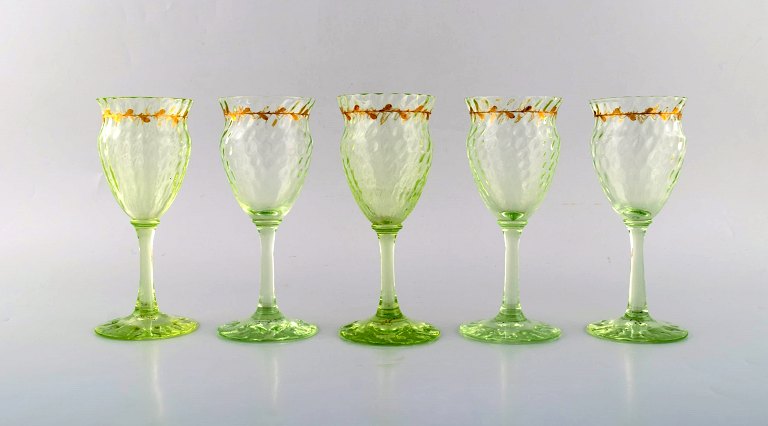 Emile Gallé (1846-1904). Fem tidlige og sjældne vinglas i mundblæst lysegrønt 
kunstglas med håndmalede guldekorationer i form af blade. Museumskvalitet, 
1870/80