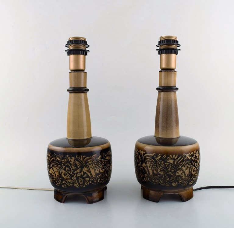 Nils Thorsson (1898-1975) for Royal Copenhagen. Two stoneware table lamps mounted on four feet decorated with fish motifs.