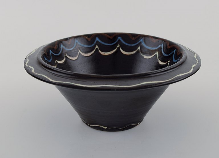 Kähler, Denmark. Bowl in black glazed ceramics with blue and white waves along the edge. 1930s / 40