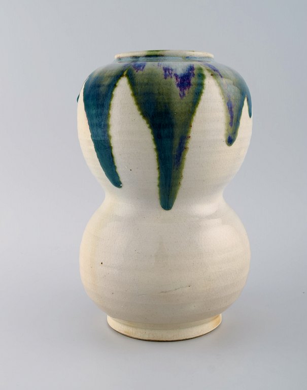 European studio ceramist. Large unique vase in glazed ceramics. Beautiful green blue glaze on a cream background. 1980