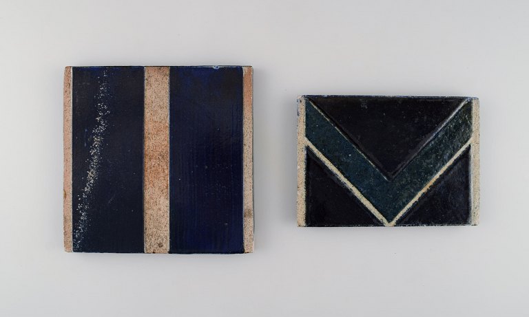 Danish studio ceramicist. Two unique tiles in glazed stoneware. Patterned decoration in dark blue, green and sand shades. Late 20th century.