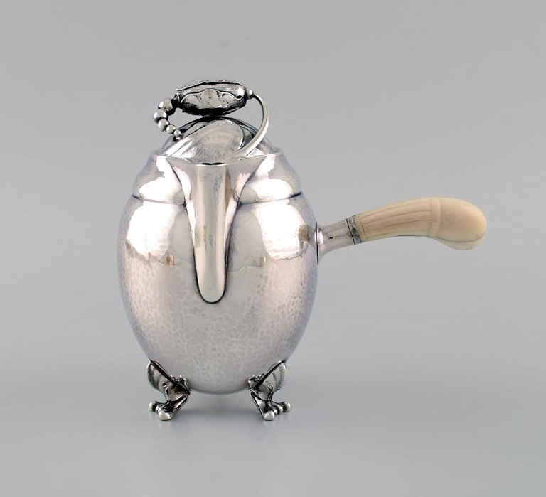 Georg Jensen Blossom chocolate pot in hammered sterling silver with handle of ivory. Model 2A. Dated 1915-1930.