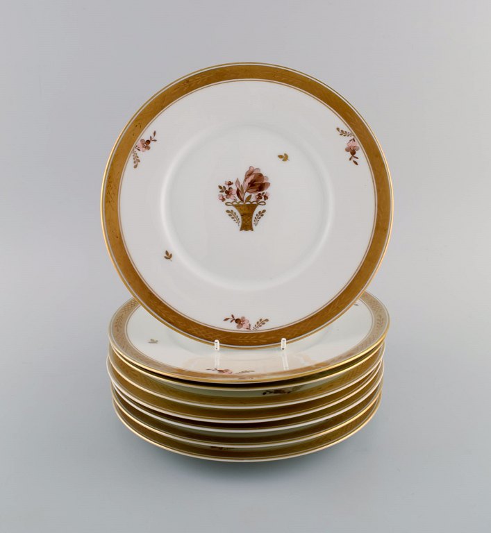 Otte Royal Copenhagen Guldkurv tallerkener i porcelæn med blomster og 
gulddekoration. Modelnummer 595/10520.
