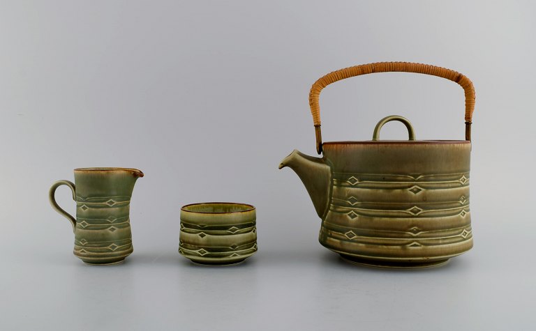 Jens H. Quistgaard (1919-2008) for Bing & Grøndahl. Rune teapot with wicker handle, sugar bowl and cream jug in glazed stoneware. 1960s / 70s.
