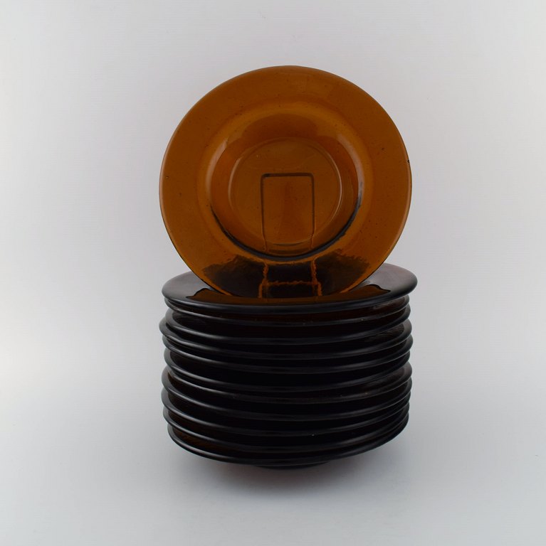 Svensk kunstglas. Tolv dybe tallerkener i røgfarvet mundblæst kunstglas. 1960/70