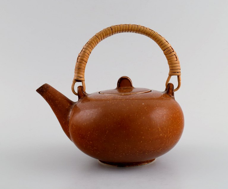 Eva Stæhr-Nielsen for Saxbo. Glazed stoneware teapot with wicker handle. Beautiful glaze in red-brown shades. Mid 20th century.