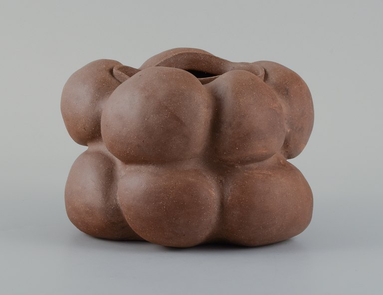 Christina Muff, dansk samtidskeramiker (f. 1971).Dark brown unglazed vessel. Organic shaped vase with lips. Clear glaze inside.