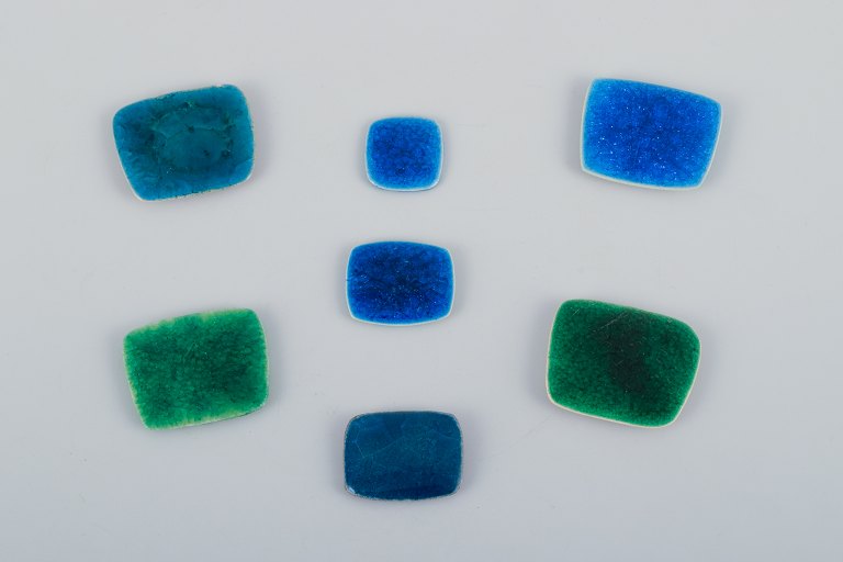Ole Bjørn Krüger (1922-2007), Danish sculptor and ceramic artist. Seven unique brooches in glazed stoneware in blue and green shades.