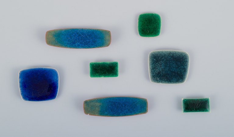 Ole Bjørn Krüger (1922-2007), Danish sculptor and ceramic artist. Seven unique brooches in glazed stoneware in blue and green shades.