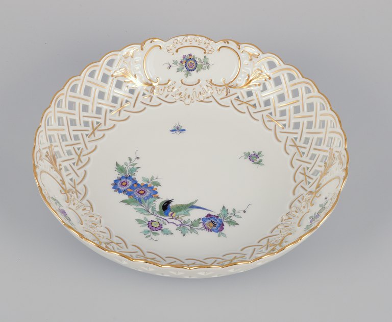 Meissen, Germany. Open lace bowl in porcelain, decorated in gold with an exotic bird on a flower branch. Hand-painted.