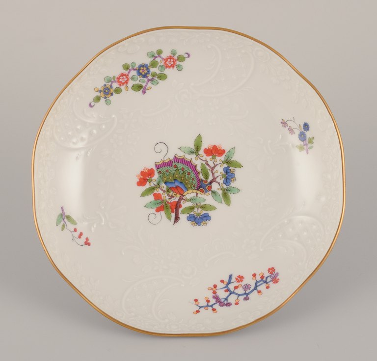 Meissen, Germany. Hand-painted dinner plate featuring a butterfly on a branch and polychrome flower motifs. Gold rim.