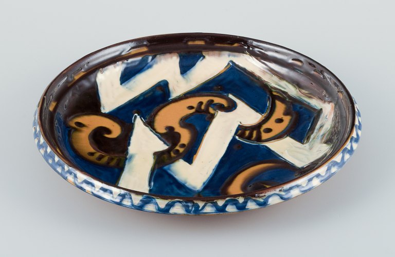 Kähler ceramic dish in cohorn technique. Abstract motif with glaze in blue, yellow, and white tones.