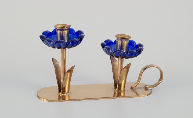 Gunnar Ander for Ystad Metall, Sweden. Candlestick holder in brass and blue art glass shaped like flowers. For two candles.