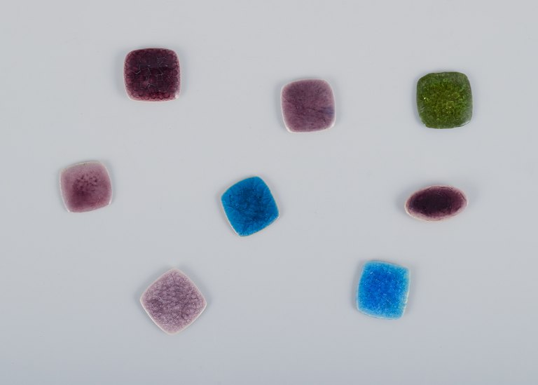 Ole Bjørn Krüger (1922-2007), Danish sculptor and ceramicist.Eight unique ceramic brooches in glazed stoneware with shades of purple, blue, and green.