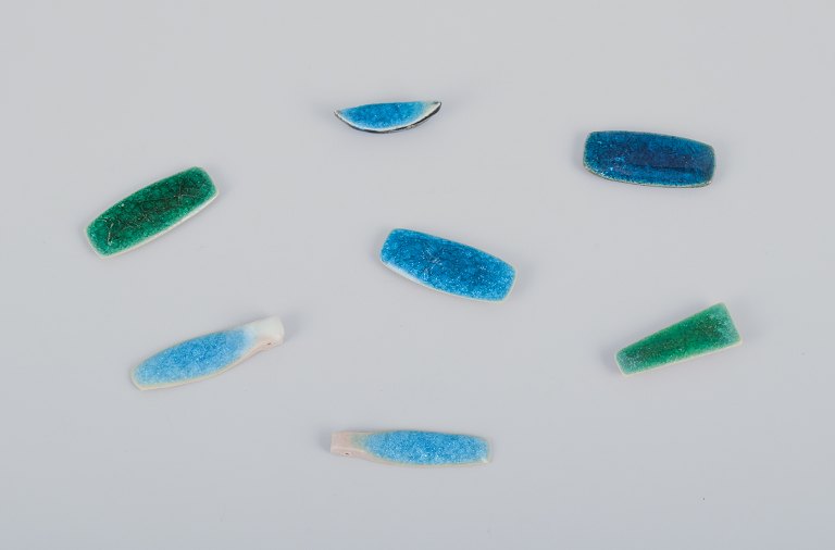 Ole Bjørn Krüger (1922-2007), Danish sculptor and ceramicist.Seven unique brooches in glazed stoneware in blue and green hues.