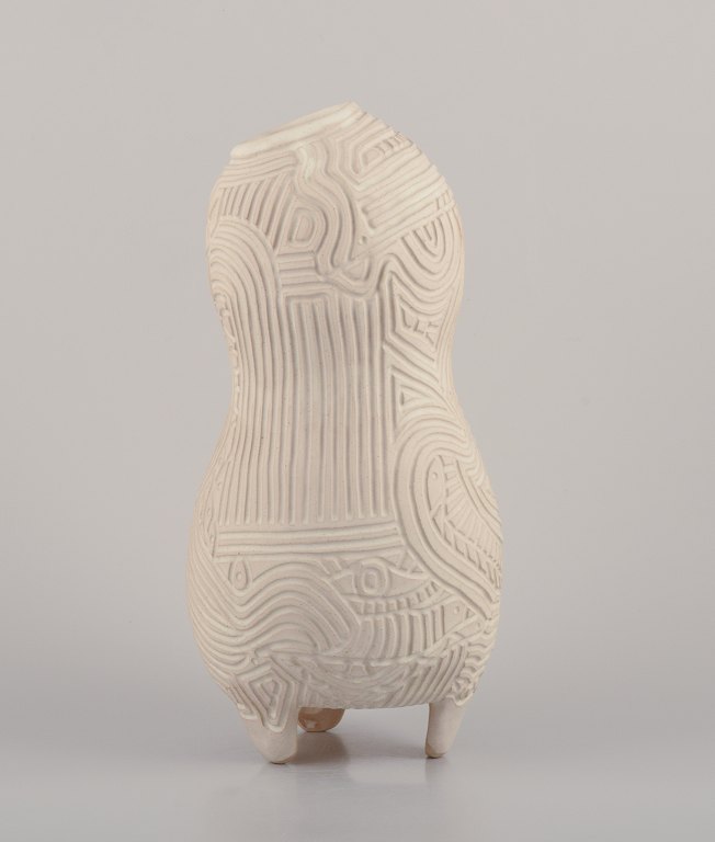Christina Muff, Contemporary Danish ceramic artist (born 1971).Unique handbuilt tall stoneware vessel. The vessel is covered in a cream glaze. The vase has symbolic carvings of eyes, fish etc.