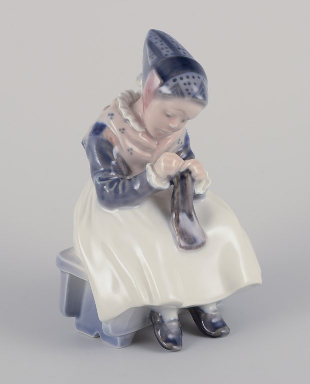 Royal Copenhagen figur i porcelæn.
Amagerpige i egnsdragt med strikketøj.