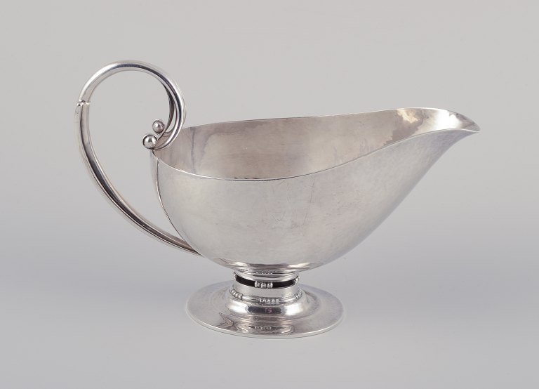 Johan Rohde (1856-1935) for Georg Jensen. Sterling silver gravy boat.Hand hammered pitcher with handle and oval foot.