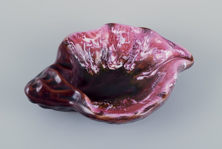 Vallauris, France, snail-shaped stoneware bowl with glaze in shades of pink and brown.