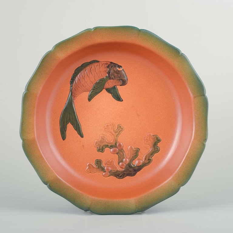 Ipsens Enke, DenmarkLarge ceramic wall plaque/decorative dish with relief decoration of fish and coral. Orange glaze with a soft green rim.
