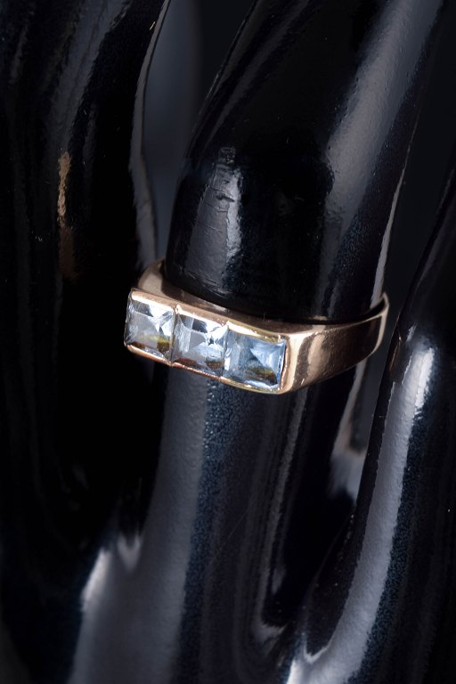 14 karat guldring med lyseblå syntetiske spineller.